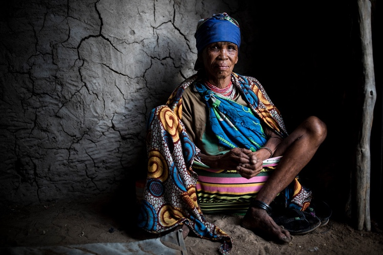 Au sits inside her mud-walled hut near Tsumkwe, Namibia